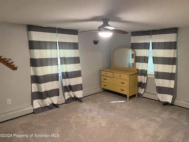 unfurnished bedroom featuring ceiling fan, baseboard heating, and light carpet