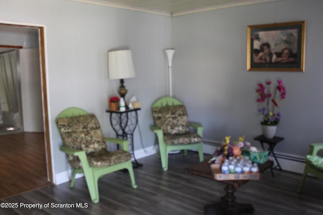 living area featuring crown molding, baseboards, wood finished floors, and baseboard heating