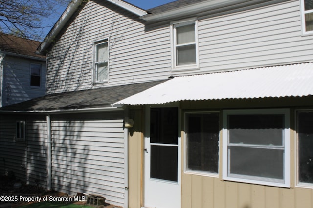 view of property exterior with a shingled roof