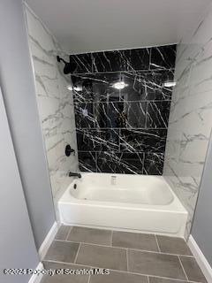 bathroom featuring tile patterned flooring and tiled shower / bath