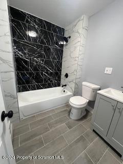 full bathroom featuring tile patterned floors, vanity, toilet, and tiled shower / bath