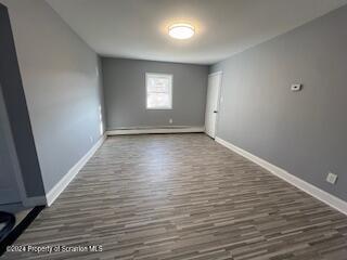 unfurnished room with dark hardwood / wood-style flooring