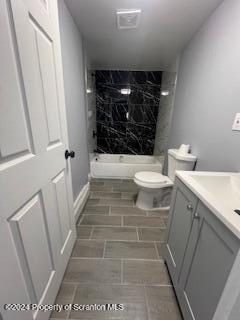 bathroom with tile patterned floors, vanity, toilet, and tiled shower