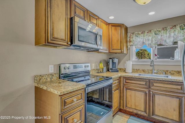 132 6th St, Blakely, PA 18447 - kitchen with appliances with stainless steel finishes, brown cabinetry, light countertops, recessed lighting, and light tile patterned floors