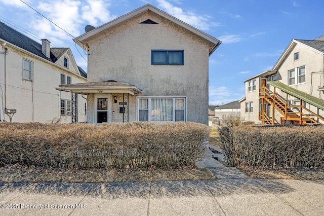 view of front of house featuring stairs and stucco siding