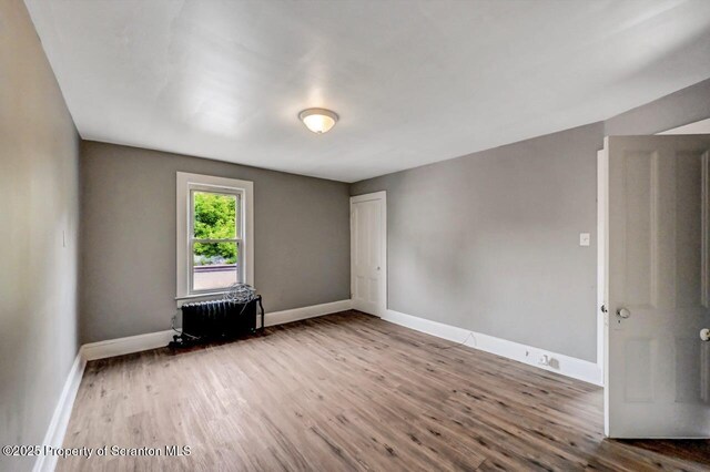 1014 Jackson St 1012, Scranton, PA 18504 - unfurnished room featuring radiator and wood finished floors