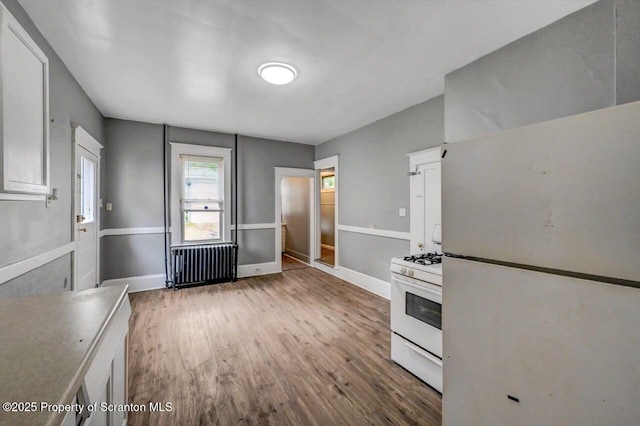 1014 Jackson St 1012, Scranton, PA 18504 - kitchen featuring white appliances, radiator, wood finished floors, and white cabinets