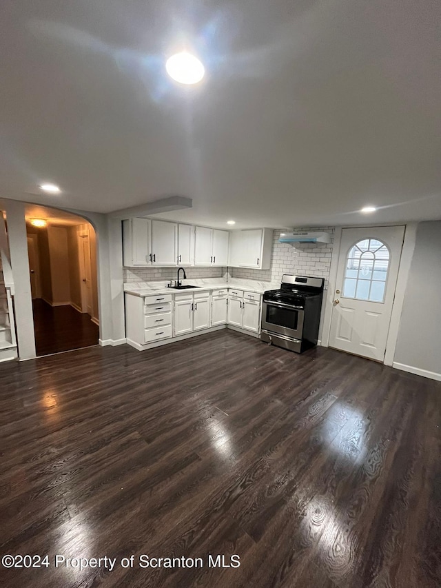 kitchen with wall chimney exhaust hood, dark hardwood / wood-style floors, stainless steel range oven, and white cabinetry