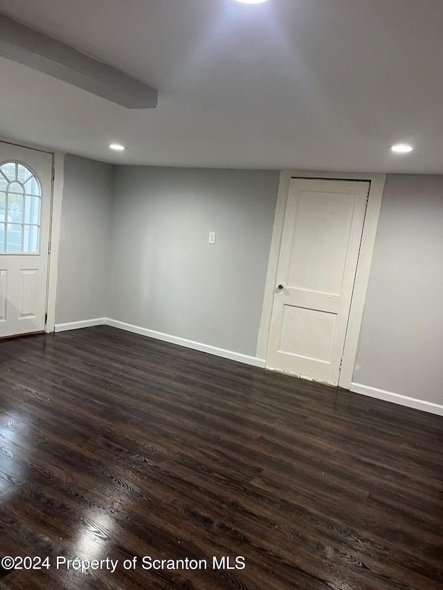 basement with dark hardwood / wood-style flooring