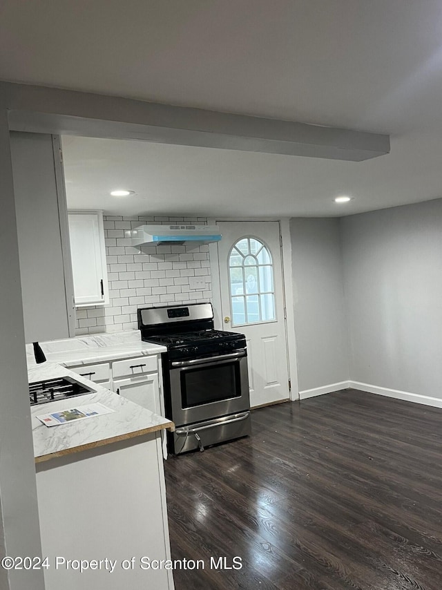 kitchen featuring stainless steel gas range oven, backsplash, white cabinets, range hood, and dark hardwood / wood-style flooring