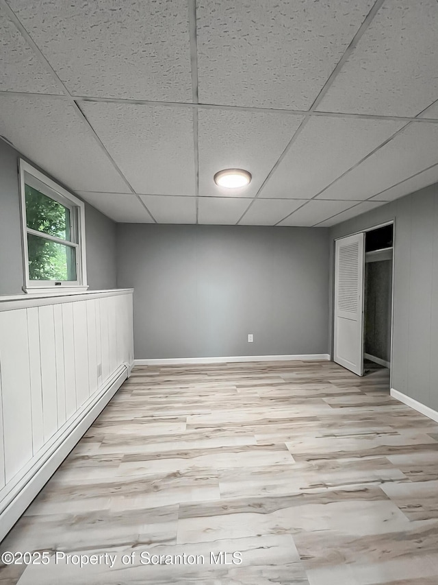 1446 Main St, Friendsville, PA 18818 - below grade area with light wood-style floors, baseboard heating, a paneled ceiling, and baseboards