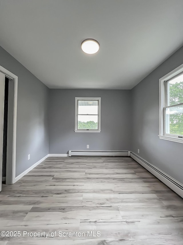 1446 Main St, Friendsville, PA 18818 - empty room featuring wood finished floors, a baseboard radiator, and baseboards