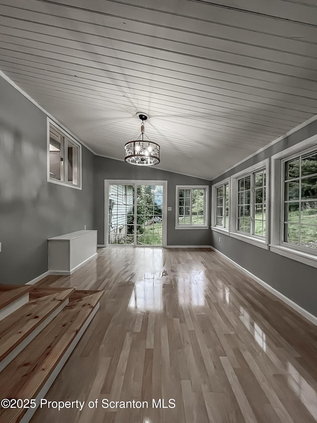 1446 Main St, Friendsville, PA 18818 - unfurnished dining area with a chandelier, vaulted ceiling, baseboards, and wood finished floors
