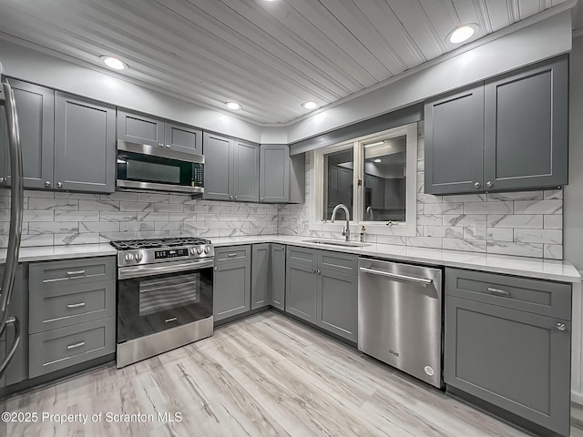 1446 Main St, Friendsville, PA 18818 - kitchen featuring stainless steel appliances, a sink, gray cabinetry, decorative backsplash, and recessed lighting