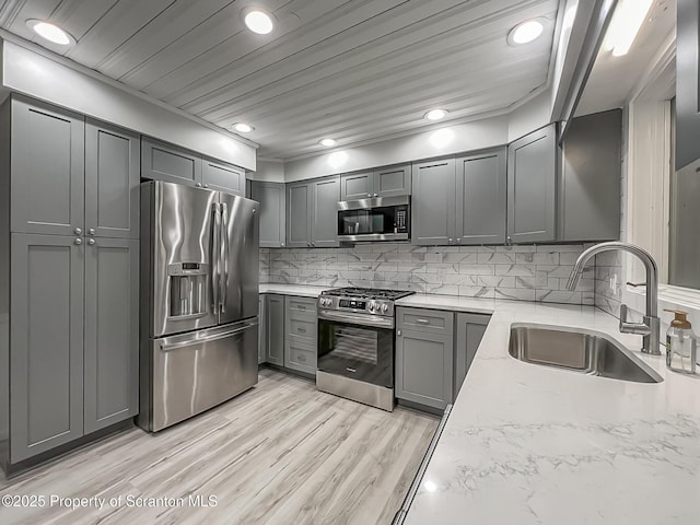 1446 Main St, Friendsville, PA 18818 - kitchen with stainless steel appliances, a sink, light stone counters, decorative backsplash, and light wood-style floors