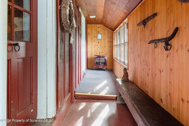 corridor featuring wooden walls, carpet, wood ceiling, and lofted ceiling