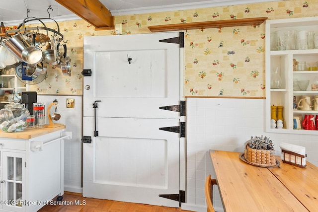 kitchen featuring beamed ceiling, parquet flooring, butcher block countertops, crown molding, and tile walls