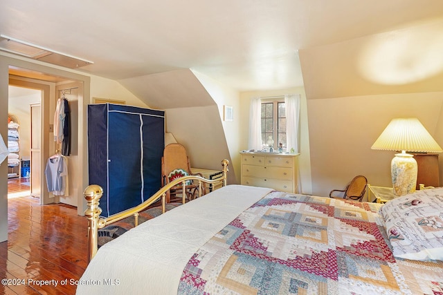 bedroom featuring hardwood / wood-style flooring and lofted ceiling