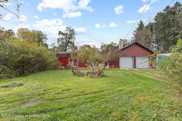 view of yard featuring a garage and an outdoor structure