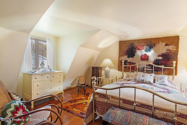 bedroom featuring vaulted ceiling and hardwood / wood-style flooring