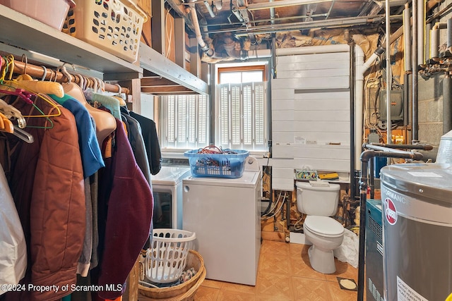 interior space with washer and clothes dryer, wood walls, and electric water heater