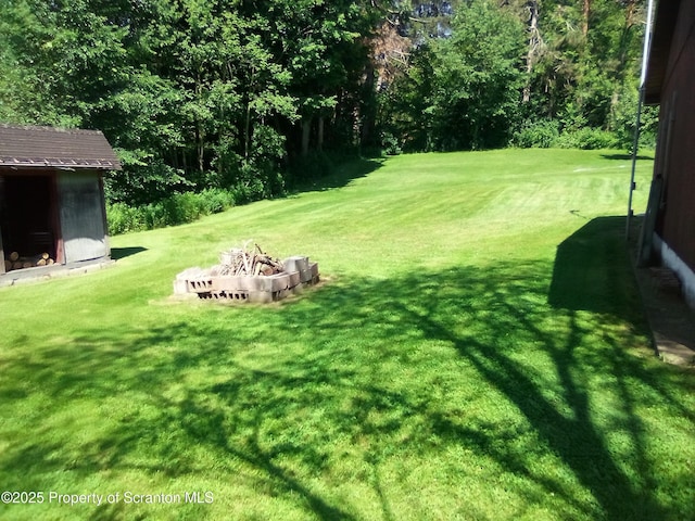 13 Mundro Rd, Scott Twp, PA 18447 - view of green lawn featuring a storage unit and an outdoor fire pit