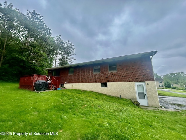 13 Mundro Rd, Scott Twp, PA 18447 - back of house featuring a lawn, brick siding, and a wooden deck
