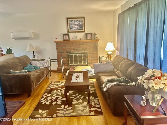 13 Mundro Rd, Scott Twp, PA 18447 - living room featuring a wall mounted AC, wood-type flooring, and a brick fireplace
