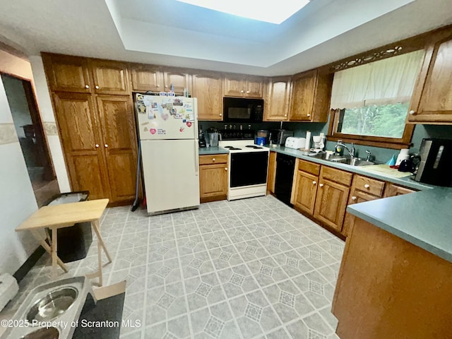 13 Mundro Rd, Scott Twp, PA 18447 - kitchen with black appliances, brown cabinets, a tray ceiling, light countertops, and light flooring