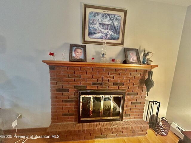13 Mundro Rd, Scott Twp, PA 18447 - detailed view of a fireplace, a baseboard heating unit, and wood finished floors