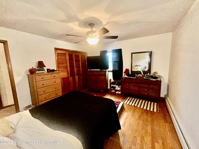 13 Mundro Rd, Scott Twp, PA 18447 - bedroom with a baseboard heating unit, wood finished floors, a closet, and a ceiling fan
