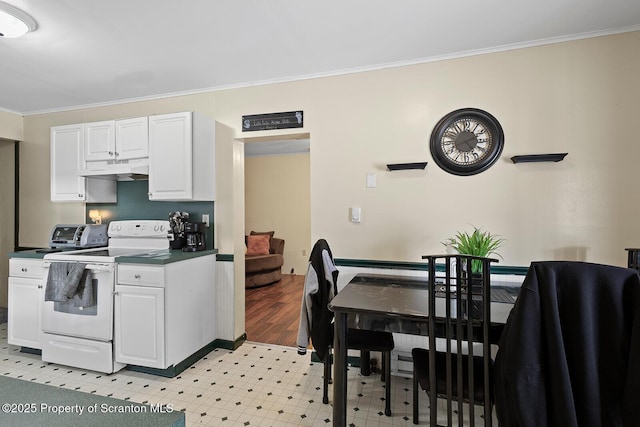 kitchen featuring crown molding, dark countertops, electric range, white cabinetry, and under cabinet range hood