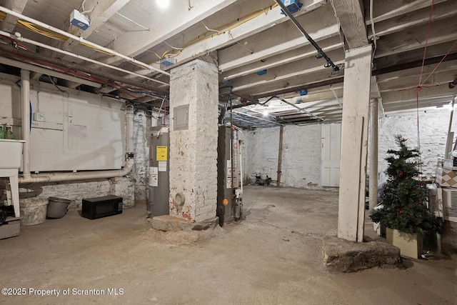 basement featuring electric water heater and water heater