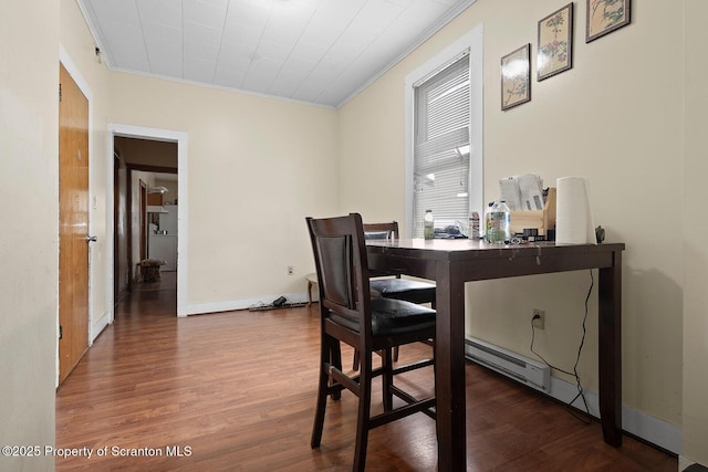 dining room featuring baseboards, baseboard heating, wood finished floors, and crown molding