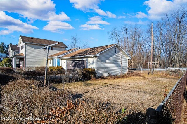 exterior space featuring a yard, fence, and a garage