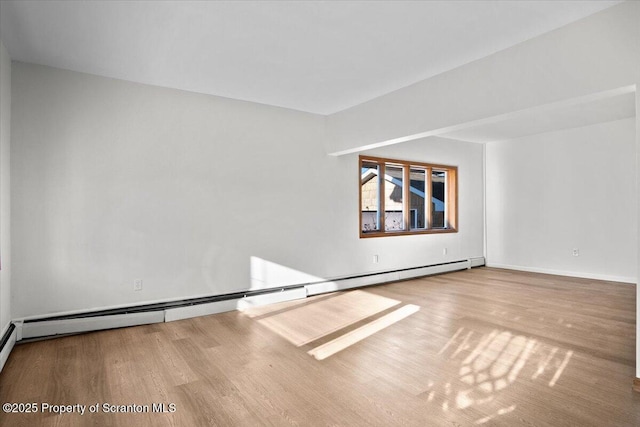 unfurnished room with wood finished floors, baseboards, and a baseboard radiator