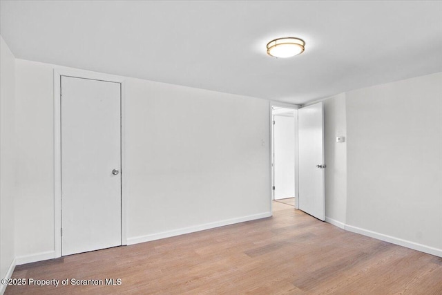 unfurnished room with baseboards and wood finished floors
