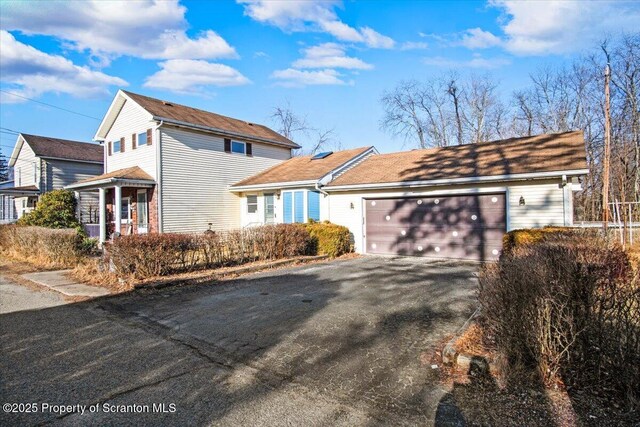 traditional home featuring aphalt driveway and an attached garage