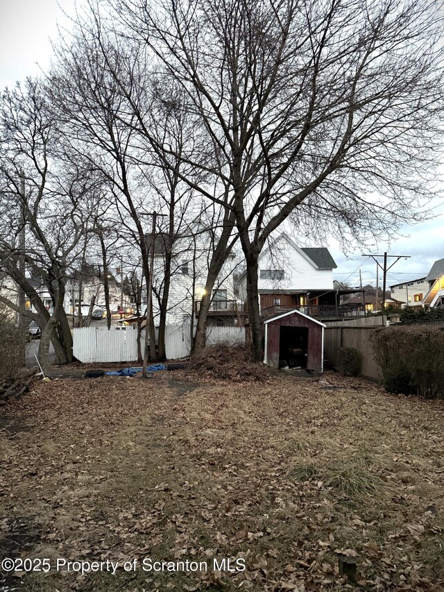 view of yard featuring fence, an outbuilding, and a shed