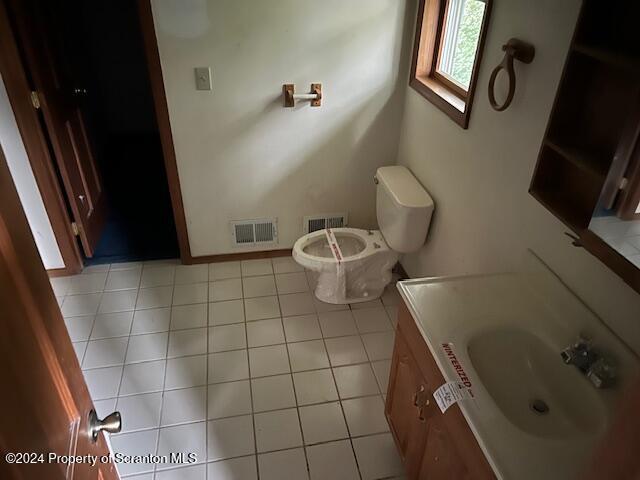 bathroom with tile patterned flooring, vanity, and toilet