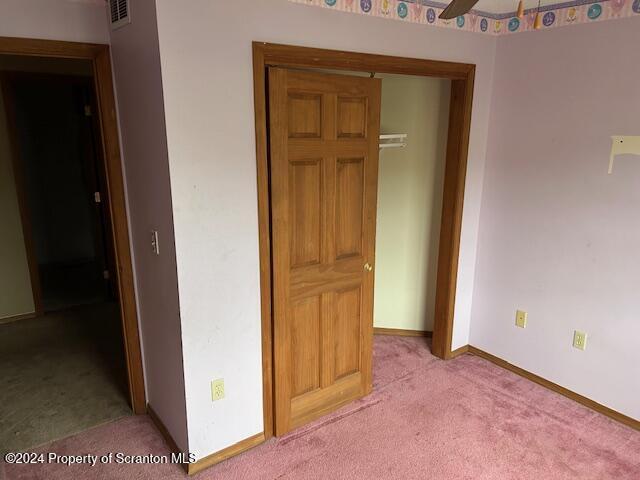 interior space featuring light carpet and ceiling fan