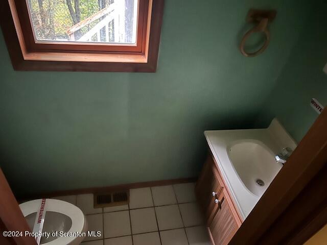 bathroom with tile patterned flooring, vanity, and toilet