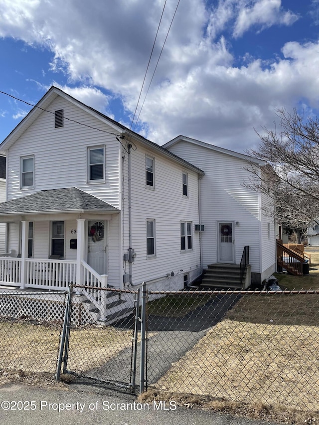 view of front of home with a fenced front yard, a porch, and a gate