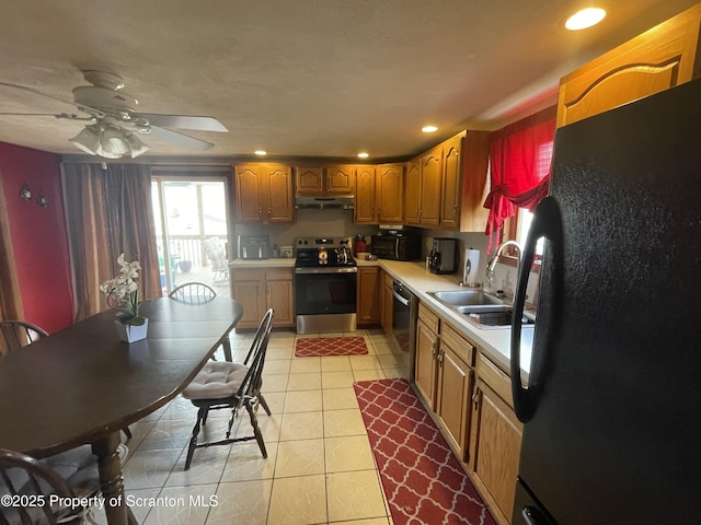 kitchen with black appliances, under cabinet range hood, a sink, light countertops, and light tile patterned floors