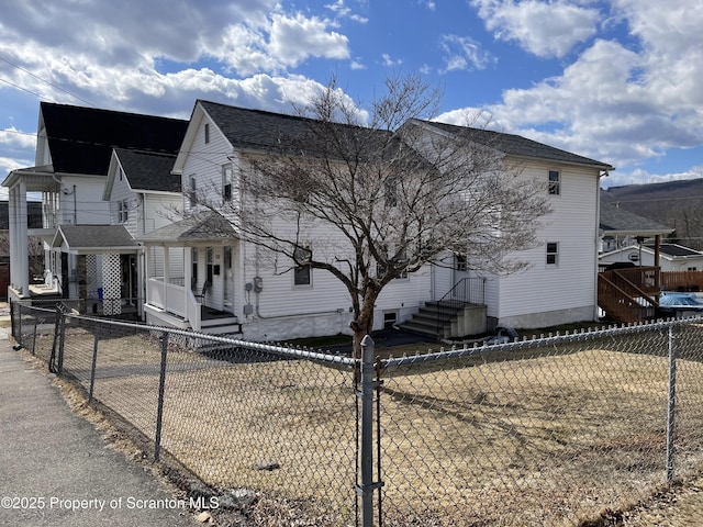 view of side of property featuring entry steps and a fenced backyard