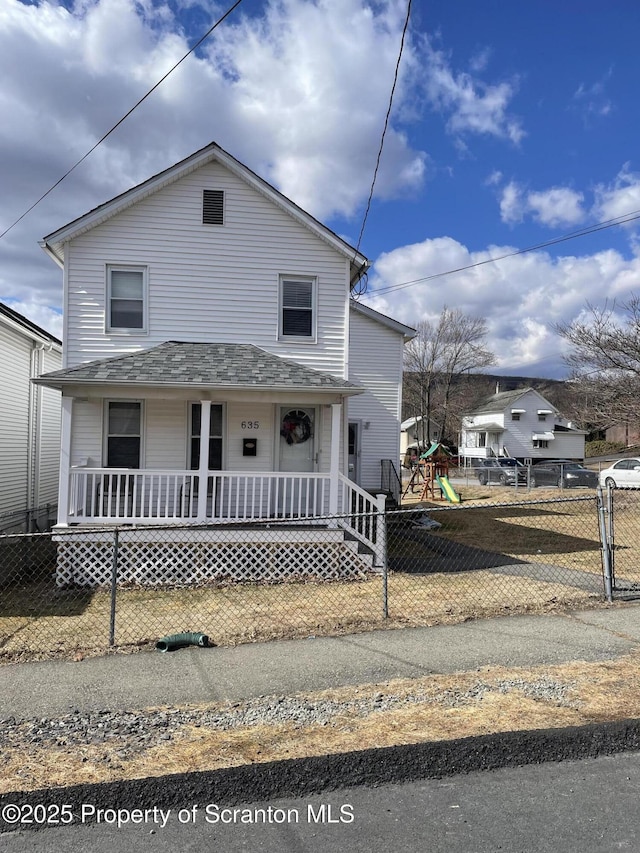 view of front of home with a porch, a playground, and fence