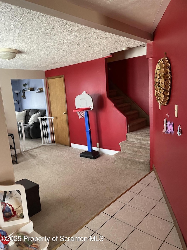 interior space featuring stairway, baseboards, a textured ceiling, and carpet flooring