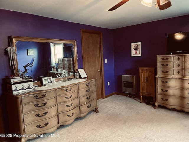 bedroom with light carpet, heating unit, and a ceiling fan