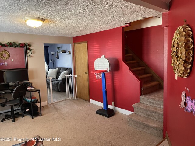 stairway with baseboards, carpet floors, and a textured ceiling