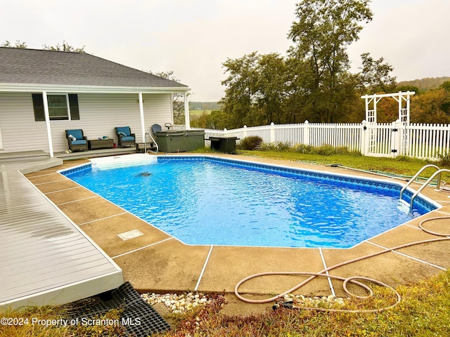 view of pool with a patio and a hot tub